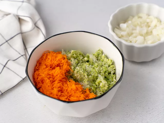 Мелко натрите морковь, нарежьте лук маленькими кусочками. Выложите их в миску к капустно-рыбной массе.