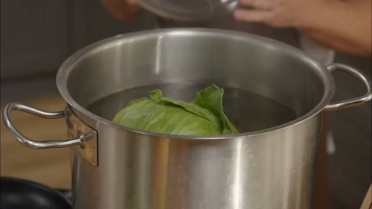 Берем кочан капусты, опускаем в кипяток, куда добавляем немного соли. Отставляем воду в сторону и ждем пока она остынет.