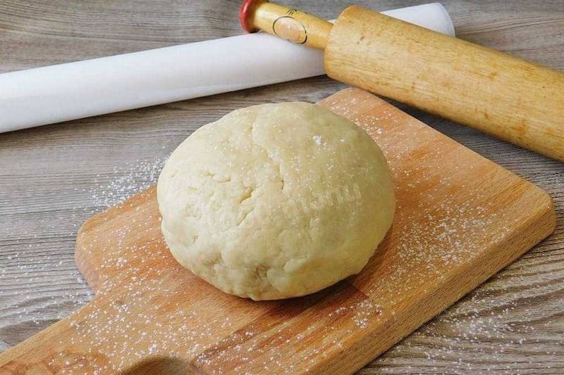Смешать оба вида муки и разрыхлитель. Масло нарезать кубиками, быстро растереть с творогом, всыпать муку. Превратить в крошку. Добавить Щепотку соли, желток, смешанный с водой, быстро замесить тесто. Поместить тесто в холодильник на 15-20 минут.