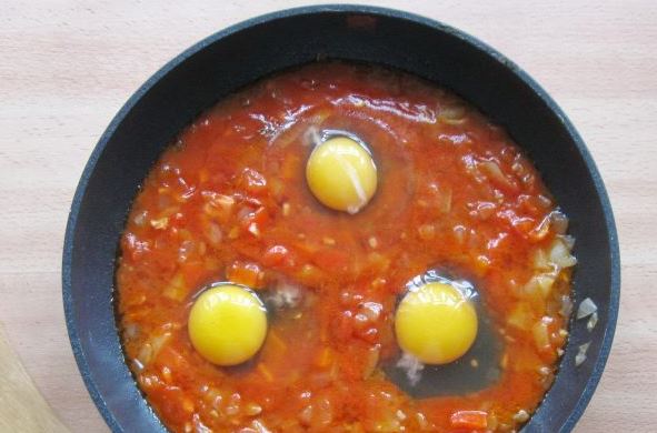 Аккуратно разбейте 3 яйца в полученную смесь и накройте сковородку крышкой. Оставьте запекаться на среднем огне до того, как схватится белок.