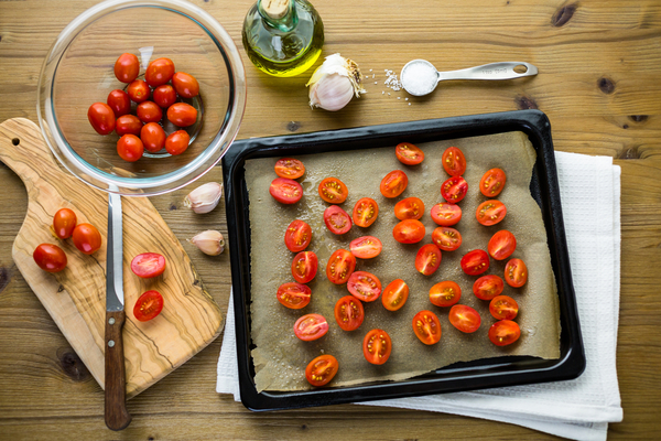 Разогрейте духовку до 180 С. Выложите помидоры на противень, сбрызните оливковым маслом, присыпьте хлопьями чили-перца, хорошо посолите и отправьте в духовку на 5-7 минут.