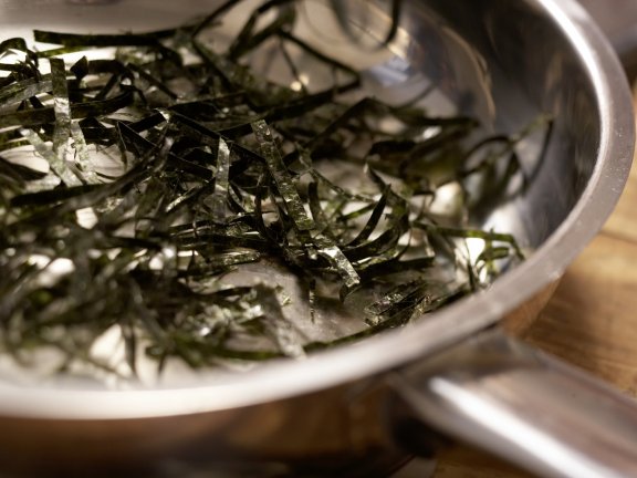 В начинку добавить стружку водорослей нори. Здесь сложно сказать по необходимому количеству водорослей, ведь они невесомые. Поэтому добавлять стоит по вкусу. Я воспользовалась кулинарными ножницами и порезала нори тонкими полосками. Начинку тщательно пере