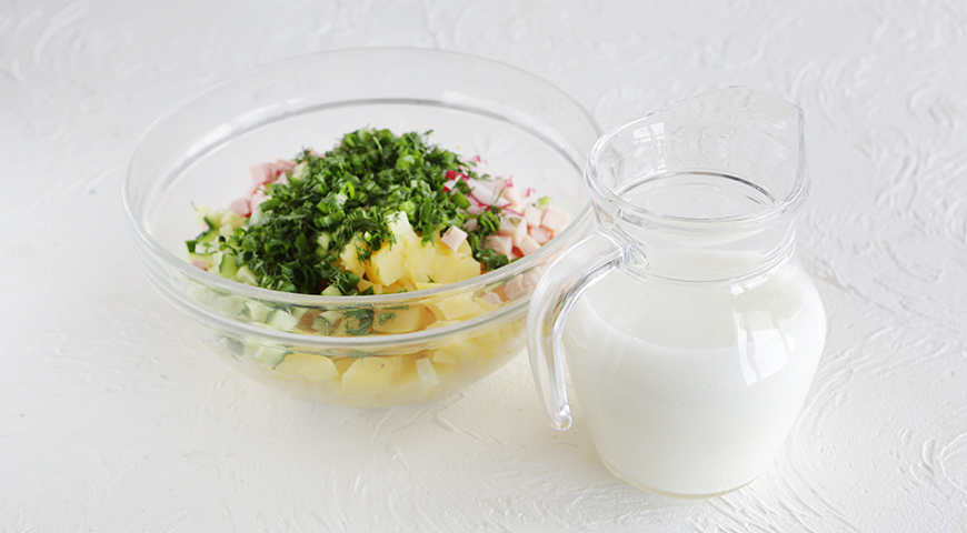 Холодную минеральную воду налейте в ковшик. Добавьте сметану и кефир, перемешайте венчиком. Залейте получившейся смесью ингредиенты окрошки в миске. Посолите, поперчите и тщательно перемешайте.