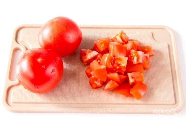 Помидоры промойте, удалите плодоножки. Если у помидоров жесткая кожица (как обычно бывает у «зимних»), снимите ее. Нарежьте их на небольшие кубики, чтобы быстрее приготовились. Добавьте в сковороду помидоры, 3 столовые ложки соуса из фасоли. Тушите на сре