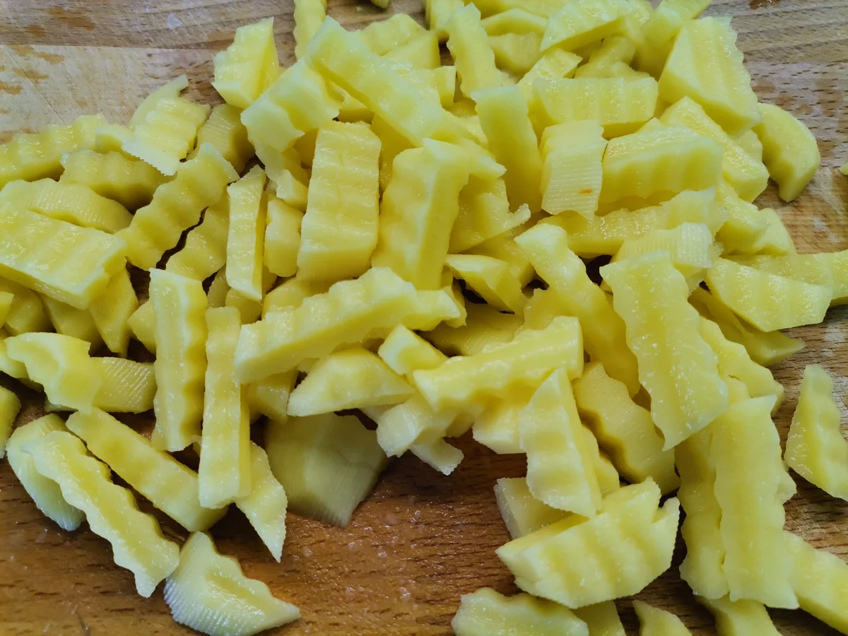 Картофель нарезаем брусочками и отправляем в бульон. Отваренную перловую крупу промываем и отпускаем в бульон к картофелю. Через 5-7 минут кладем пассерованные лук и морковь.