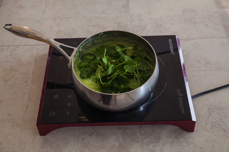 Удалите из кастрюли лавровый лист и измельчите суп при помощи блендера. Посолите и поперчите. Снимите кастрюлю с огня и добавьте в суп шпинат. Накройте кастрюлю крышкой, оставьте на 3 мин. – шпинат за это время увянет, затем перемешайте.