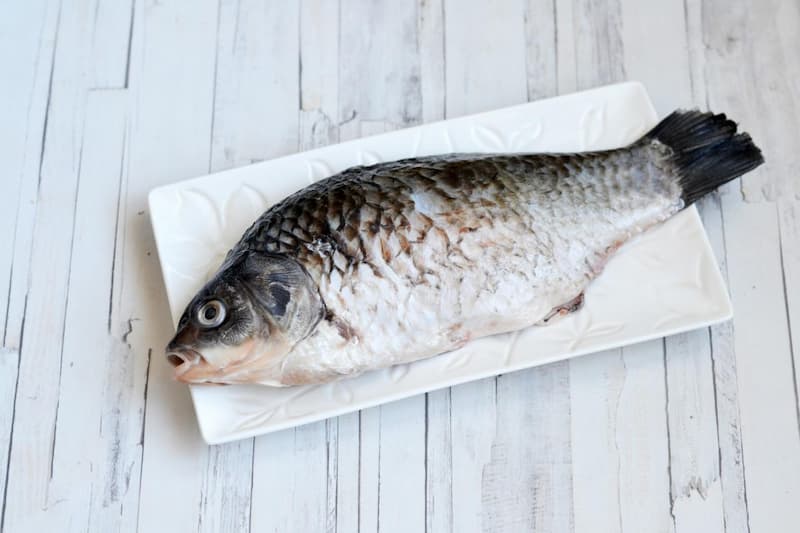 Карася лучше брать свежего, но если он у вас замороженный, то предварительно разморозьте. Рыбу очистить от чешуи и внутренностей, удалить жабры и плавники, тщательно промыть. Промокнуть сухими салфетками, чтобы не осталось лишней жидкости. 