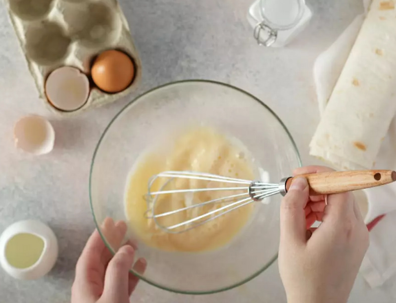 В отдельной миске взбейте 1 яйцо с молоком, растительным маслом и солью.