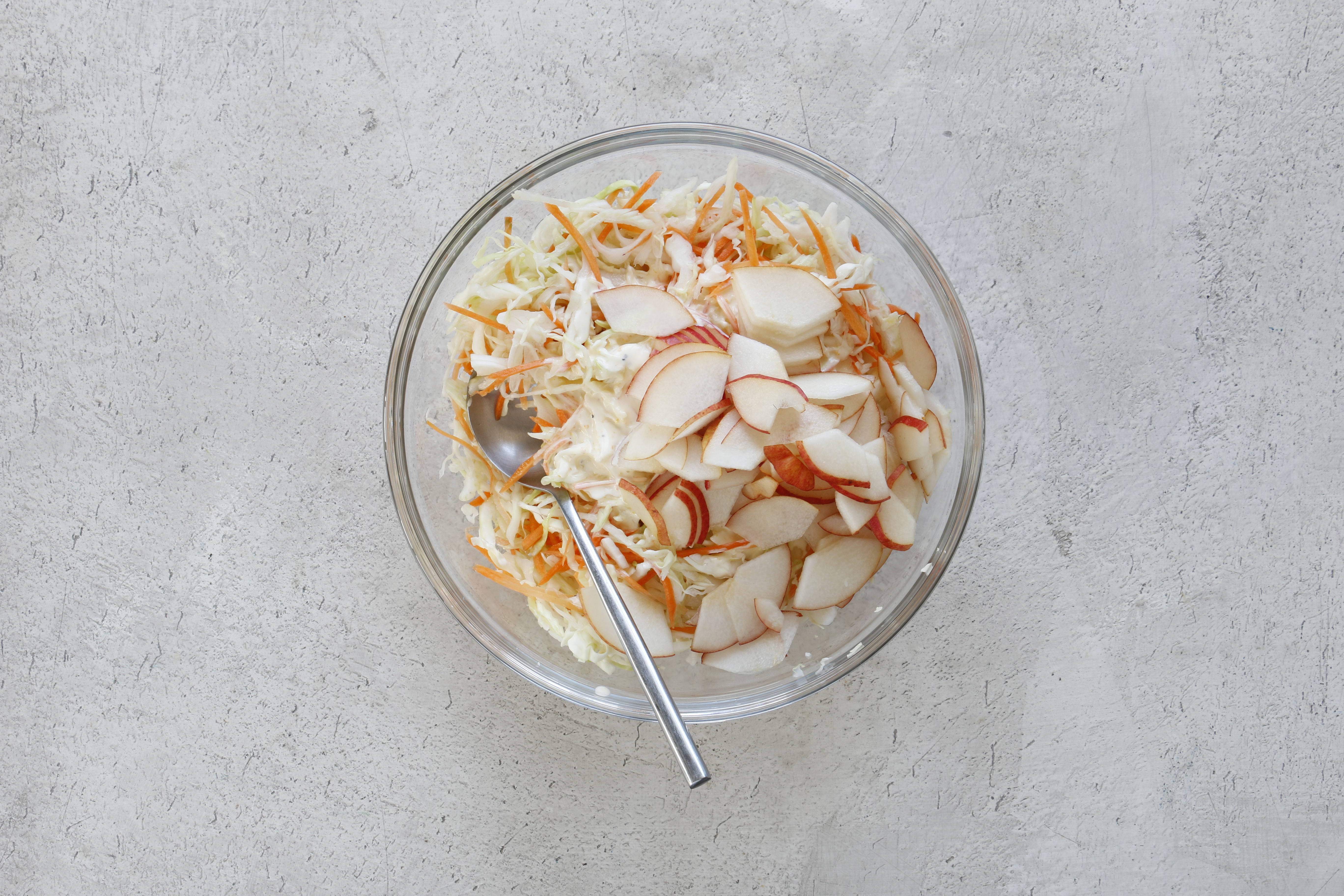 Полейте заправкой капусту с морковью, добавьте грушу и перемешайте. Сразу же подавайте.