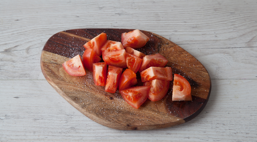 Помидоры для салата вымойте и обсушите бумажным полотенцем. Нарежьте кубиками и сложите в отдельную миску. Посыпьте сахаром и щепоткой соли. Оставьте на 10 минут.