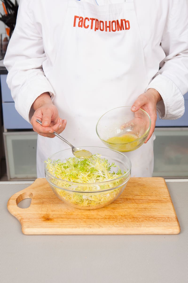 Салат фризе нарвите на длинные кусочки. Полейте салат частью заправки и перемешайте. Выложите фризе на прямоугольное или овальное блюдо. На салатные листья выложите шампиньоны. Добавьте грецкие орехи в оставшуюся заправку, перемешайте и выложите на грибы.