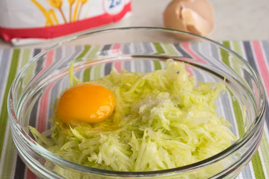 Переложите кабачковую массу в миску подходящего размера. Добавьте яйца, посолите. Перемешайте до однородного состояния.