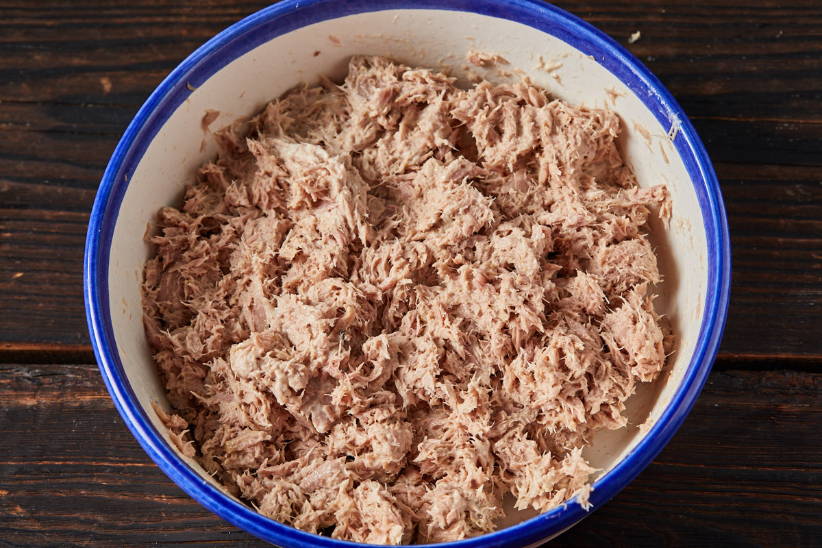 Приготовить начинку. Филе консервированного тунца смешать с майонезом. Структура начинки должна быть мелко-однородной, поэтому разминать и смешивать рыбу удобнее вилкой.