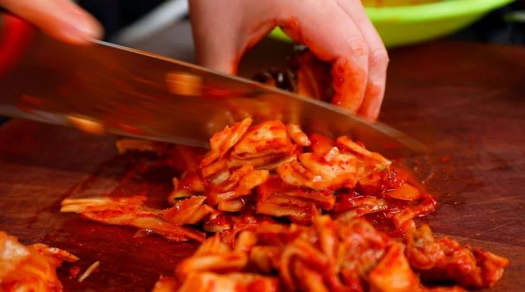 К мясному фаршу добавляем сыр тофу. Если в нем слишком много рассола, отжимаем его перед добавлением. Капусту по-корейски, кимчи, мелко нарезаем, добавляем к мясу и сыру. Вливаем соевый соус и размешиваем фарш до однородности. Можно мешать вилкой или рука