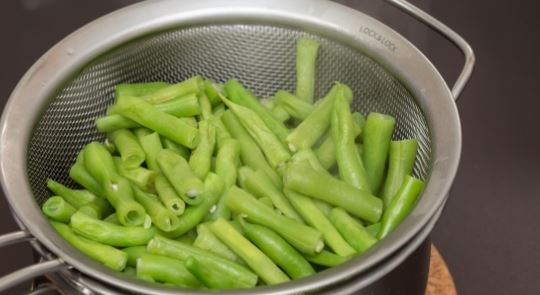Фасоль помыть, и после проварить в кипящей воде около 3 минут.