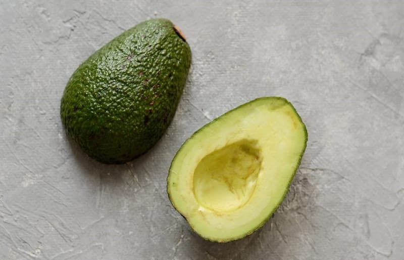 Разрежьте авокадо пополам, выньте из него косточку.