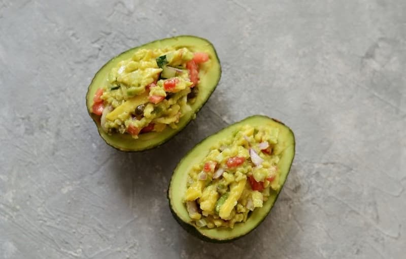 Заполните лодочки из авокадо полученной овощной смесью.