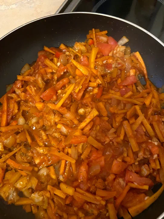 Смешать рыбу с овощами, посолить, поперчить, добавить томатную пасту или очищенные томаты, нарубленный чеснок, потушить все еще минут 10. Потом выключить плиту, накрыть сковороду крышкой и оставить доходить. 
Подавать с зеленью. Хорошо сочетается с молодо