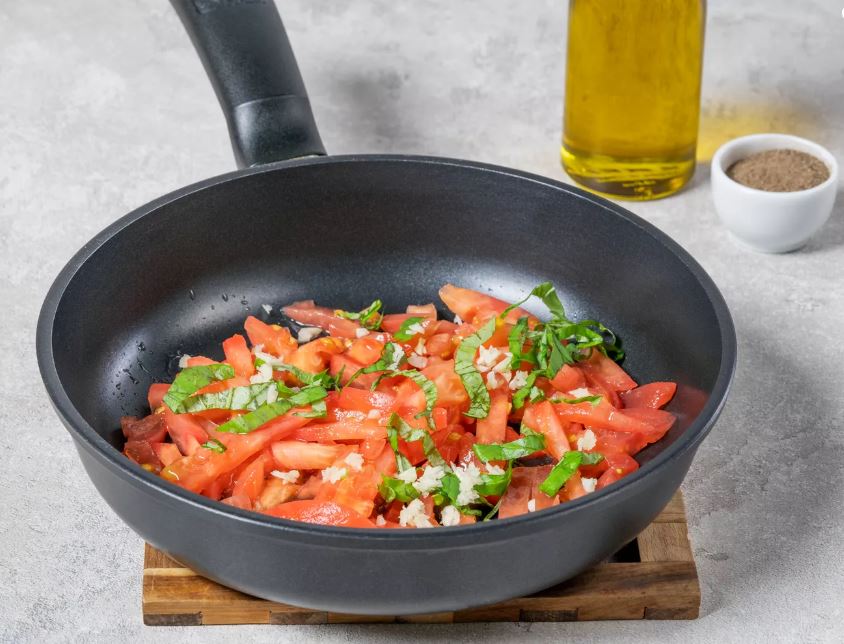 Томаты и базилик обжарьте 10 минут на раскаленной сковороде с маслом. В конце добавьте чеснок, соль и перец. Перемешайте.