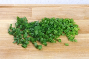 Берём зелёный лук, моем его и мелко нарезаем. Чем мельче, тем лучше, так как тогда он не будет горчить в салате.
