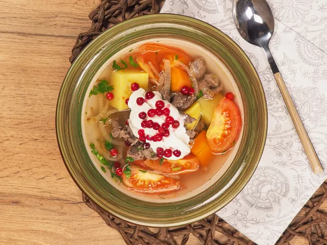 Соедините продукты. В бульон положите кусочки оленины, добавьте зажарку, приправьте солью и добавьте зелень. Варите 10 минут, затем снимите с плиты.