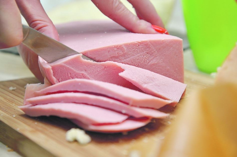 Сосиску (или ветчину, колбасу) нарезать ломтиками. Добавить к тесту и перемешать.