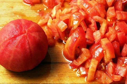 Приготовить соус. Для этого томаты хорошо промыть и убрать плодоножку. Снизу каждого помидора сделать небольшой крестообразный надрез. Он нужен для того, чтобы в дальнейшем нам было легче очистить томаты от кожуры. Залить подготовленные помидоры кипятком.