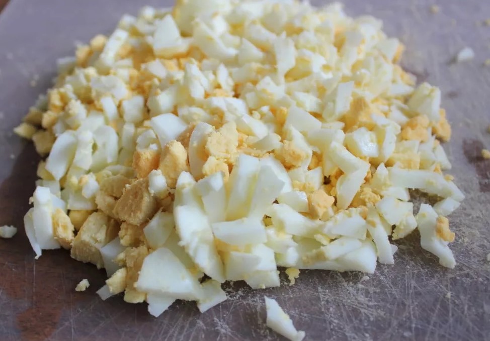 Сваренные яйца мелко порубить и смешать с капустой.