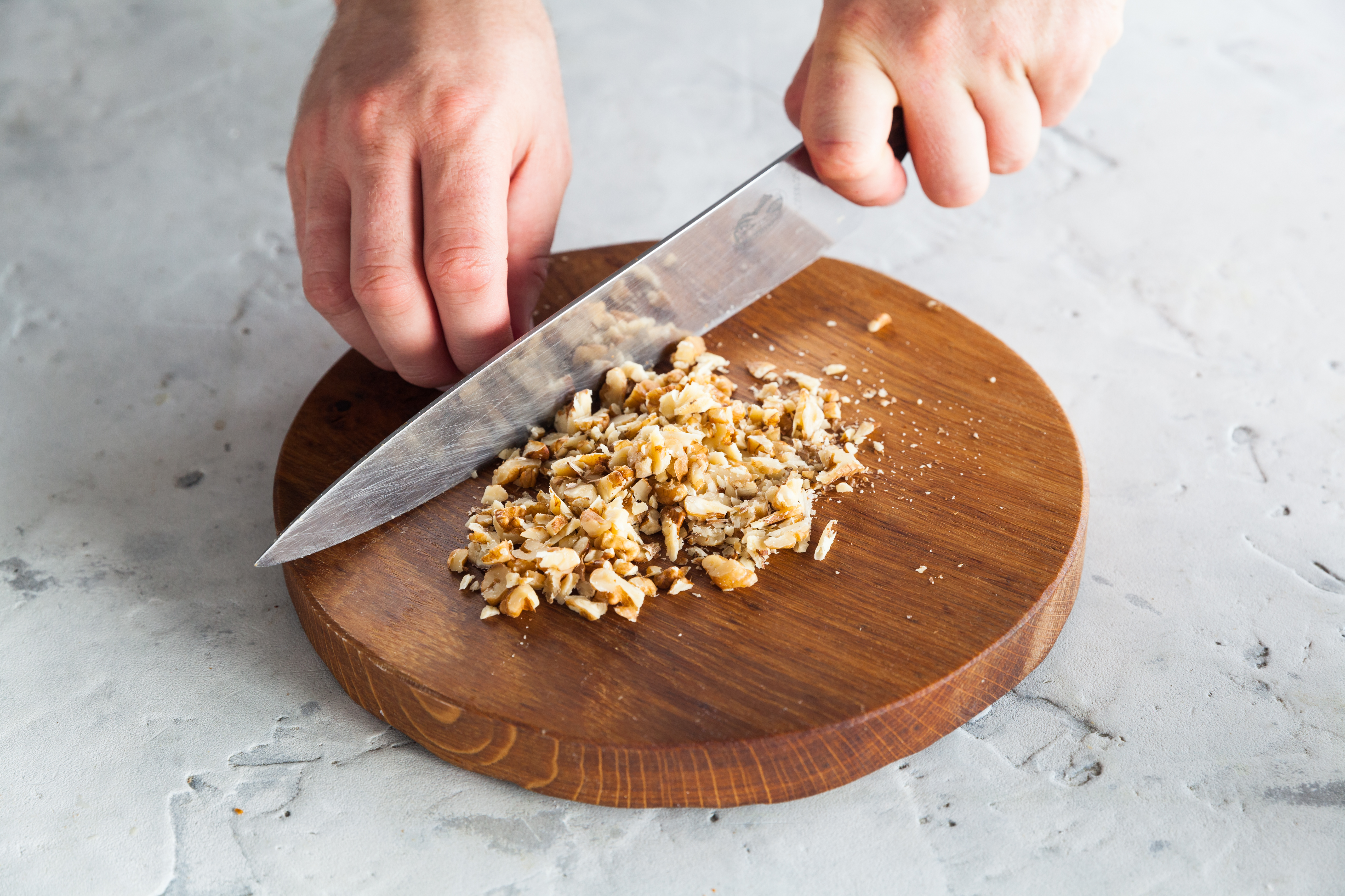 Орехи выложите на сухую сковороду и, помешивая, подрумяньте в течение 7–10 минут на слабом огне до появления аромата. Дайте остыть и крупно порубите ножом.