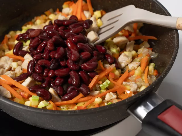 Добавьте к овощам с курицей фасоль. Поперчите ингредиенты по вкусу.