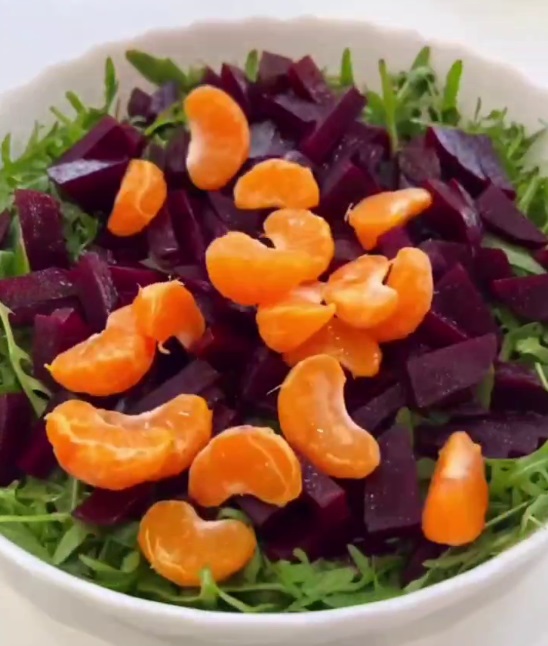 На свеклу выложить дольки мандарина.