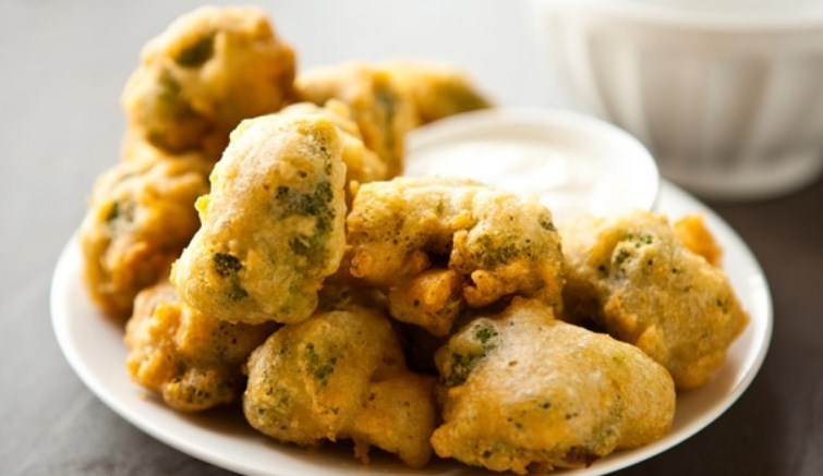 В посуде с толстым дном как следует разогрейте растительное масло.  Кладите брокколи в кипящее масло и готовьте на небольшом огне, периодически переворачивая. Время готовки около 7–10 минут, до золотистого цвета кляра. Ничего страшного, если капуста несил