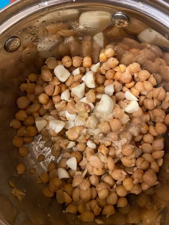 Слейте жидкость, оставив один стакан про запас. Засыпьте нут в блендер, добавьте оливковое масло, нарезанный чеснок (его можно предварительно ошпарить кипятком, чтобы вкус был мягче), тхину и лимонный сок, молотую паприку. 
Тхина у меня готовая, но если у