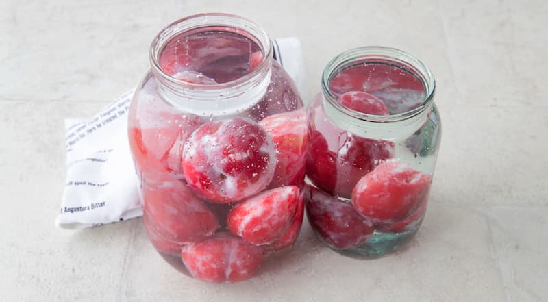 Разложите сливы по трем банкам. В большой кастрюле вскипятите воду. Залейте кипяток в каждую банку до самого верха, прикройте крышкой и оставьте на 5 мин.