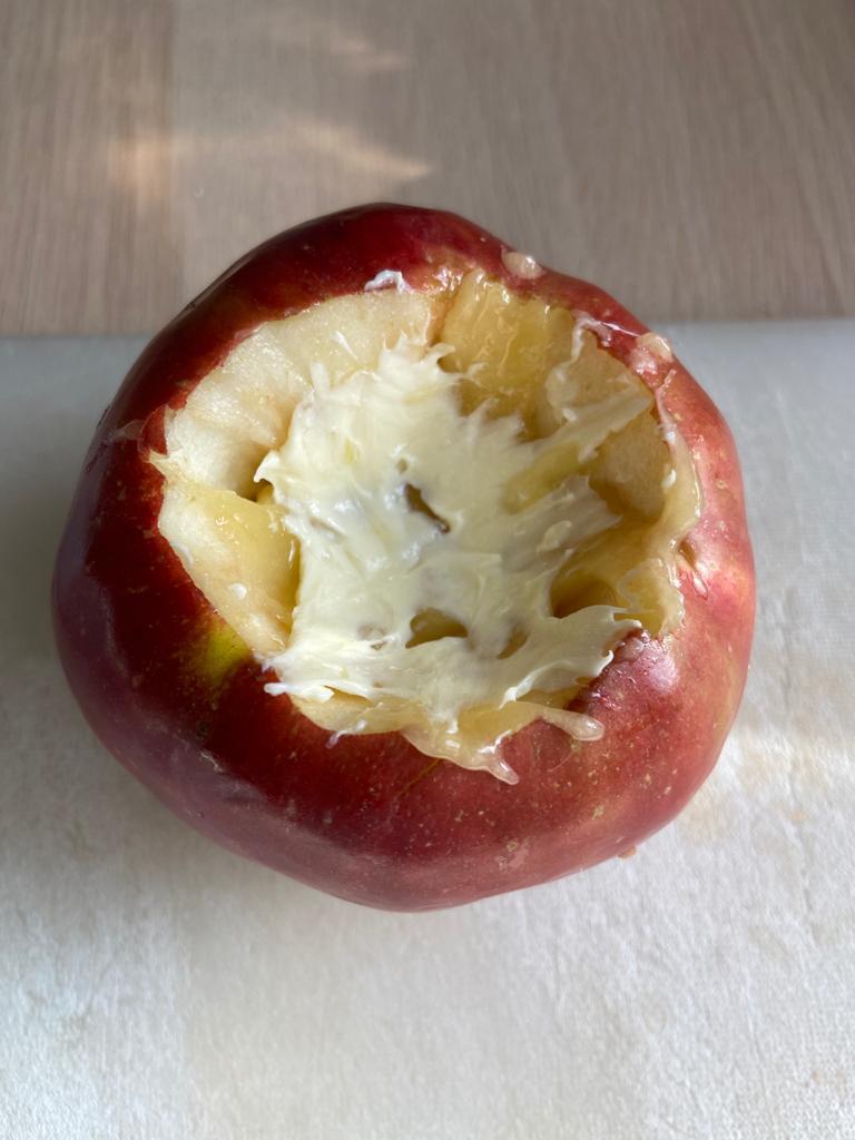 Смазываем яблочное «нутро» маслом. Это по желанию. Мне кажется, что так вкуснее. А жена говорит, что это – ни к чему, лишние калории. В пустую серединку яблока укладываем творог