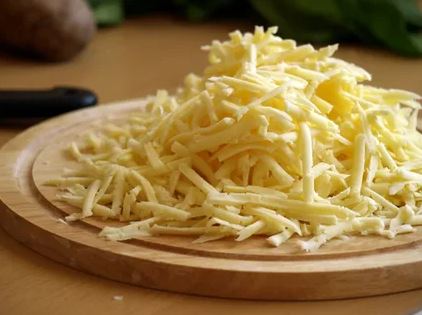 Сыр натрите на средней терке, отложите немного для украшения.