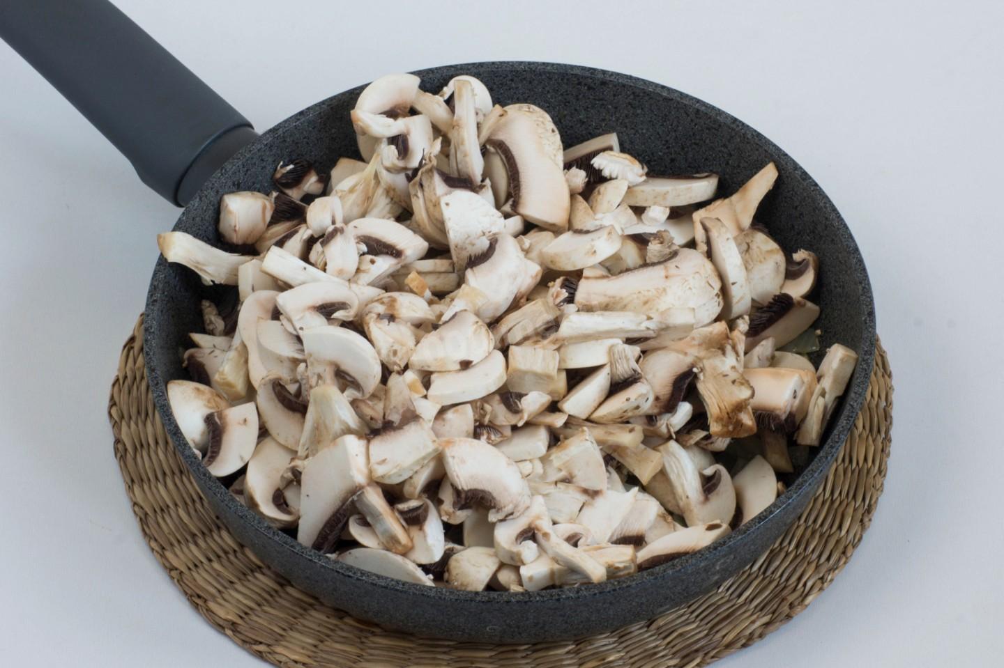 Пока овощи и грибы варятся, вторую половину шампиньонов мелко нарезать и обжарить на сухой сковороде (без масла).
