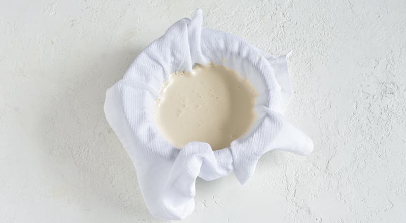 Подготовьте все ингредиенты десерта. Для слоя из ряженки откиньте ее на застеленный полотенцем дуршлаг и дайте стечь такому количеству жидкости, чтобы осталось 600 мл ряженки.