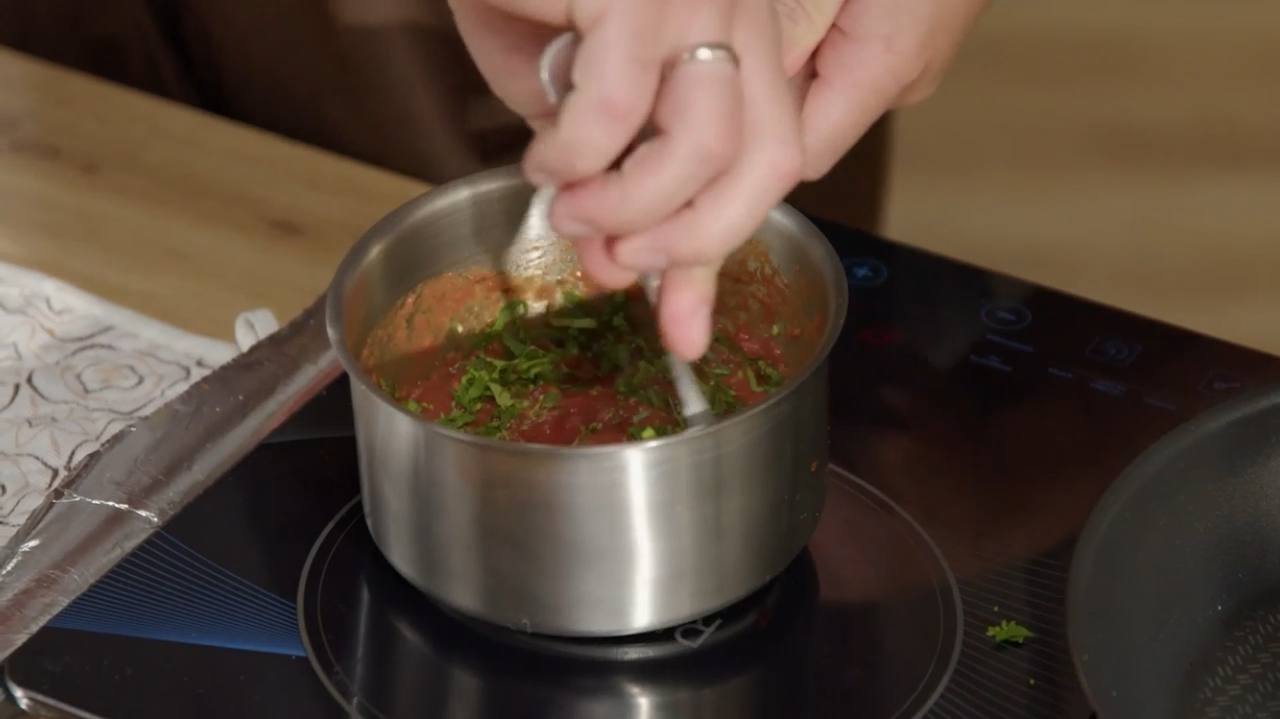 Готовим соус. Берем спелые томаты, натираем их на терке и закидываем на сковороду. Выпариваем лишнюю жидкость. Добавляем немного оливкового масла, соль, перец и рубленную зелень.