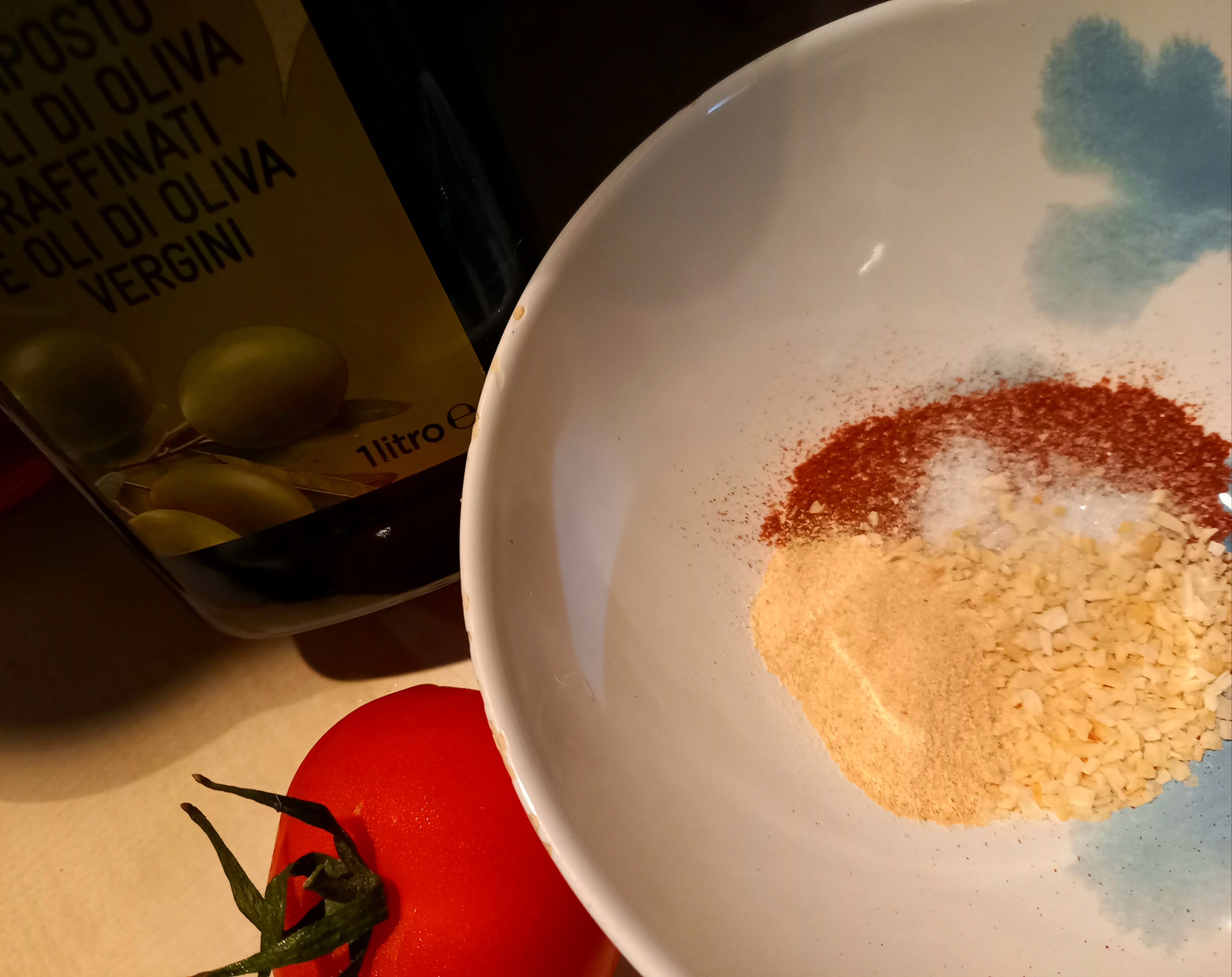 В отдельной тарелочке готовим заправку из дюбимых специй - сухие лук и чеснок, немного соли, Хмели-сунели. При желании можно добавить любимый вид перца. Добавляем оливковое масло, чтобы аромат специй раскрылся и получился густой соус.