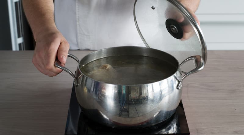 Приготовьте бульон для харчо. Для этого говядину вымойте и разрежьте на 4-5 кусков. Сложите в большую кастрюлю, залейте водой и варите 1,5 часа, периодически снимая пену.