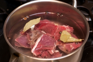 Возьмите говядину или телятину, помойте ее.
Затем проварите мясо. Поместите его в кастрюлю, добавьте такое количество холодной воды, чтобы она полностью покрыла мясо. В воду добавьте соль, лавровый лист, душистый перец. Когда вода в кастрюле закипит, засе