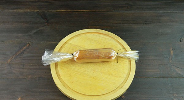 Завернуть мясную порцию в пленку в 3–4 слоя (можно больше), придавая форму вытянутой тонкой колбаски. По краям обязательно закрутить пленку и завязать, уплотняя фарш.