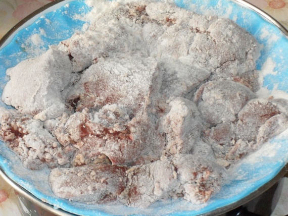 Переложите аккуратно печень в миску с мучной смесью и хорошенько обваляйте ее со всех сторон. 