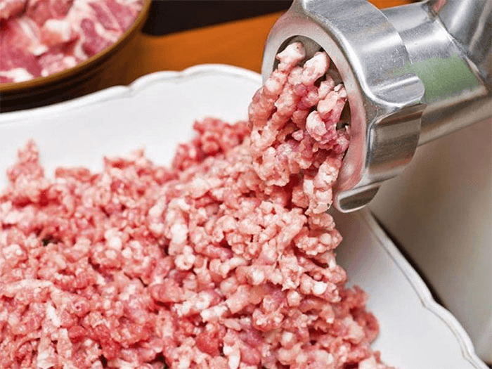 Свинину и говядину моем, просушиваем и режем небольшими кусочками, подходящими для измельчения в мясорубке. Пропускаем мясо через мясорубку. Репчатый лук и чеснок чистим, моем и режем мелкими кубиками. Зеленый лук также моем и мелко рубим. Добавляем все о