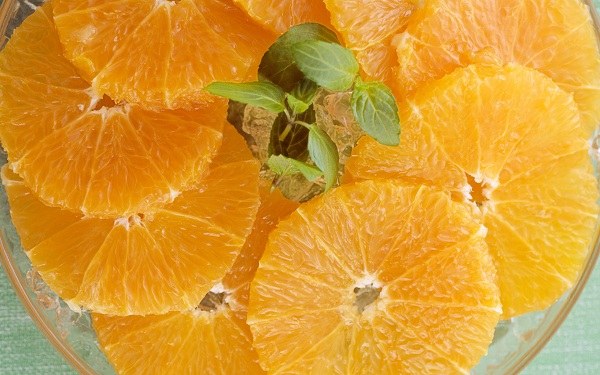 Апельсин освободить от цедры и порезать половинками кружочков.  Авокадо очистить и нарезать ломтиками.